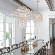 a dining room table with chairs and a chandelier hanging from it's ceiling