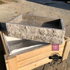 a stone sink sitting on top of a wooden box