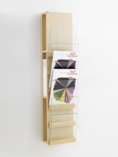 a book shelf with three different colored umbrellas hanging on it's sides,