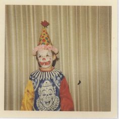 an old photo of a clown with a hat on and his face painted like a clown