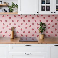 a kitchen counter with a potted plant on top of it next to a cutting board