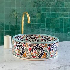 a bathroom sink with an ornate design on the bowl and faucet next to it