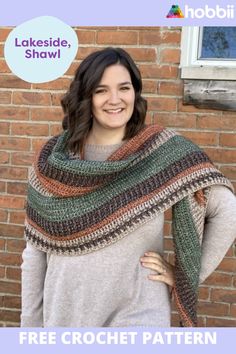 a woman standing in front of a brick wall wearing a crochet shawl