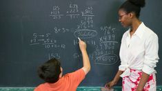 a woman teaching a boy how to write on a chalkboard with numbers and symbols