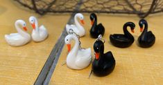 several black and white ducks sitting next to each other on a table with scissors in front of them