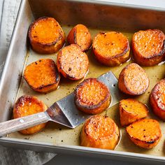 cooked sweet potatoes in a baking pan with a spatula on the side, ready to be eaten