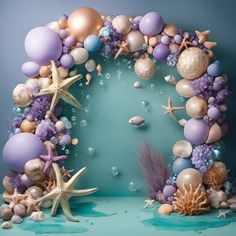 an arch made out of balloons and seashells with starfish on the bottom