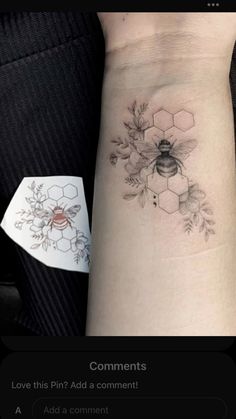 a woman's arm with a bee and flowers tattoo on it