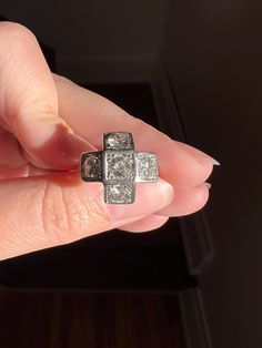 a woman's hand holding an old fashioned ring with two square diamonds on it