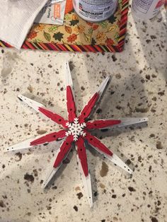 a red and white snowflake sitting on top of a counter next to some scissors