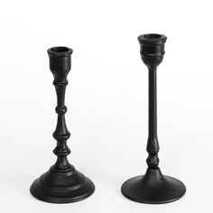 two black candlesticks sitting next to each other