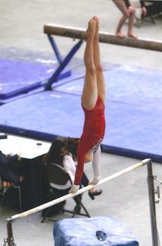 a person on a balance beam doing a handstand