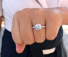 a woman's hand with a diamond ring on it