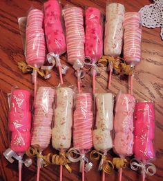 pink and white candy lollipops wrapped in cellophane on a wooden table