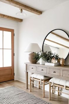 a white room with a mirror, table and bench