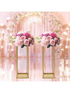 two gold vases with pink flowers on them