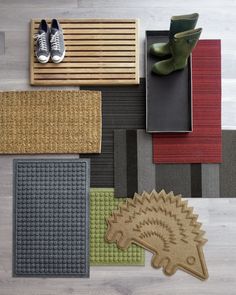 various rugs and floor mats arranged on top of each other, including one with a hedgehog