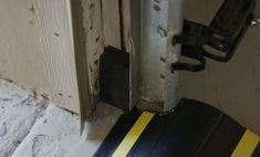 an open door with a black and yellow strip on the floor next to it's handle