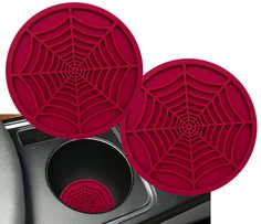 two red spider web coasters sitting on top of a stove