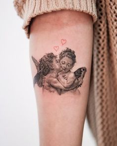 a tattoo with two cherubs on the arm