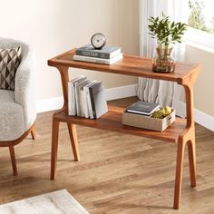 a small wooden table with books on it and a chair in the corner next to it