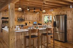 a kitchen with wooden walls and flooring next to a refrigerator