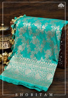 A pretty color of turquoise is aesthetically decorated with floral jaal work in zari all over. Katan Silk is a fabric known for its luster and softness! When this beautiful fabric and design come together, it is a match made in heaven! This saree comes with an unstitched blouse fabric and is ready to wear with fall and pico complete. Handmade tassels line the pallu. SILK MARK CERTIFIED Note: There may be a slight difference in shade between the actual product and what you see on screen due to va Blue Sharara With Traditional Drape And Zari Weaving, Turquoise Saree With Zari Work For Puja, Traditional Turquoise Wear With Zari Weaving, Turquoise Saree For Wedding And Eid, Traditional Turquoise Saree With Zari Weaving, Turquoise Banarasi Silk Traditional Wear, Turquoise Pallu Saree, Turquoise Saree With Cutdana For Puja, Turquoise Traditional Wear With Zari Weaving