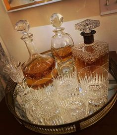 an assortment of wine glasses and liquor bottles on a tray