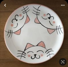 a white plate with two cats painted on the front and back of it's face