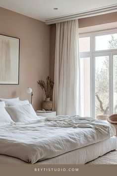 a bed with white sheets and pillows next to a window