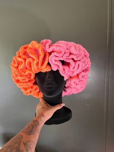 a mannequin's head with two crocheted hats on top of it