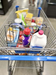 a shopping cart filled with lots of food and drinks on top of a store floor