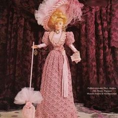 the doll is wearing a pink dress and hat with a cane in her hand,