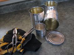 several tin cans and tools are sitting on the floor