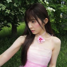 a young woman in a pink dress posing for the camera with her hand on her hip