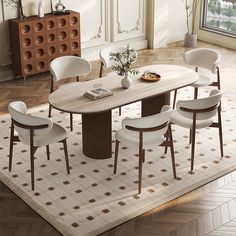 a dining room table with white chairs and a rug on the floor in front of it