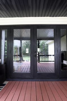 two black doors are open on a deck