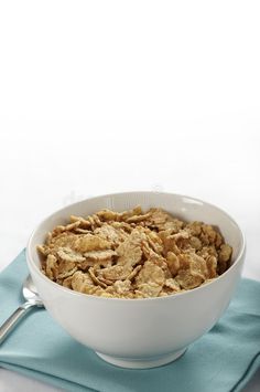 cereal in a white bowl on a blue napkin with a silver spoon royalty images and stock photos