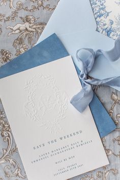 a blue and white wedding save the date card with ribbon on it next to an envelope