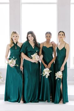 four bridesmaids in green dresses posing for the camera