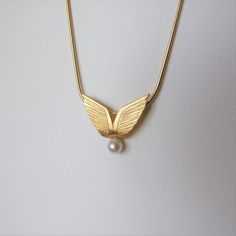 "This is a unique necklace, inspired by angel wings. It's very elegant and is great to give as a gift. It's made of 14k gold and you can choose which color 14k gold it will be made of - yellow or white gold I plate the white gold with rhodium, as is common in white gold jewelry. There is a single natural white pearl attached to the bottom of the pendant and the pendant has an elegant matte finish. The size of the pendant is 0.81 / 0.7 inches ( 2.1 / 1.8 cm ) Choose the length of the necklace you Elegant Gold Wing-shaped Jewelry, Elegant Wing-shaped Gold Jewelry, Elegant Gold Winged Jewelry, Elegant Gold Winged Necklace, Elegant Wing-shaped Yellow Gold Necklace, Elegant Winged Gold Jewelry, Elegant Yellow Gold Wing-shaped Necklace, Elegant Jewelry Pendant With Angel Wings, Gold Winged Necklace Perfect As A Gift