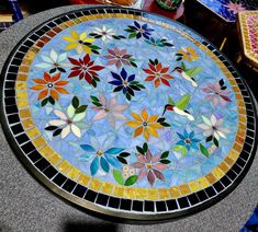 a glass table topped with lots of colorful flowers