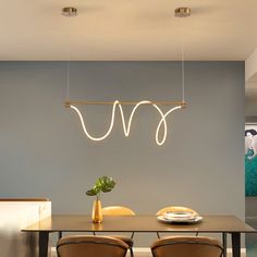 a dining room table with four chairs and a light hanging over it's head