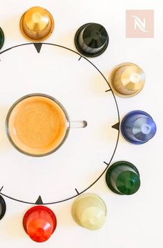 a coffee cup sitting in the middle of a circle with eight different colored cups around it