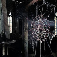 a spider web in the middle of a room with stained glass windows