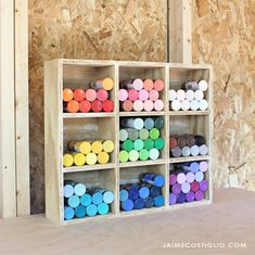 a wooden shelf filled with lots of different colored crayons on top of it