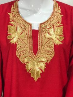 a mannequin wearing a red shirt with gold embroidery on the chest and shoulders