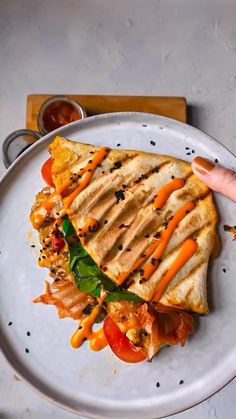 a grilled cheese tortilla wrap has been placed on a plate with the words, kimchi grilled cheese tortilla wrap hack