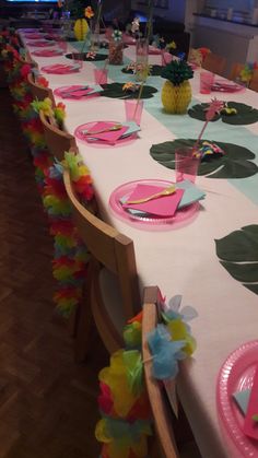 a table set up for a party with plates and pineapples on it,