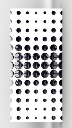 a white and black poster with circles on it's side, hanging from the wall